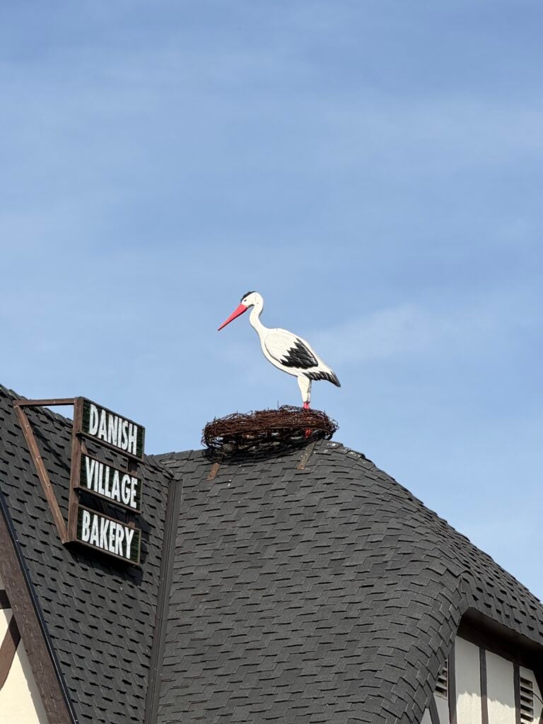 stork nest on top of house with wooden stork