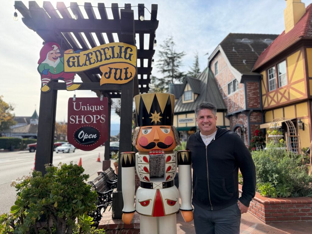 man next to life-size nutcracker in town