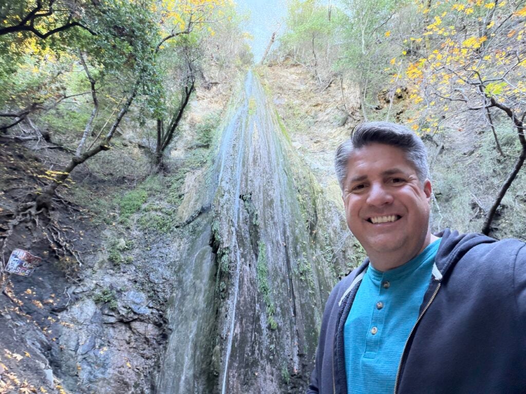 man in front of waterfall