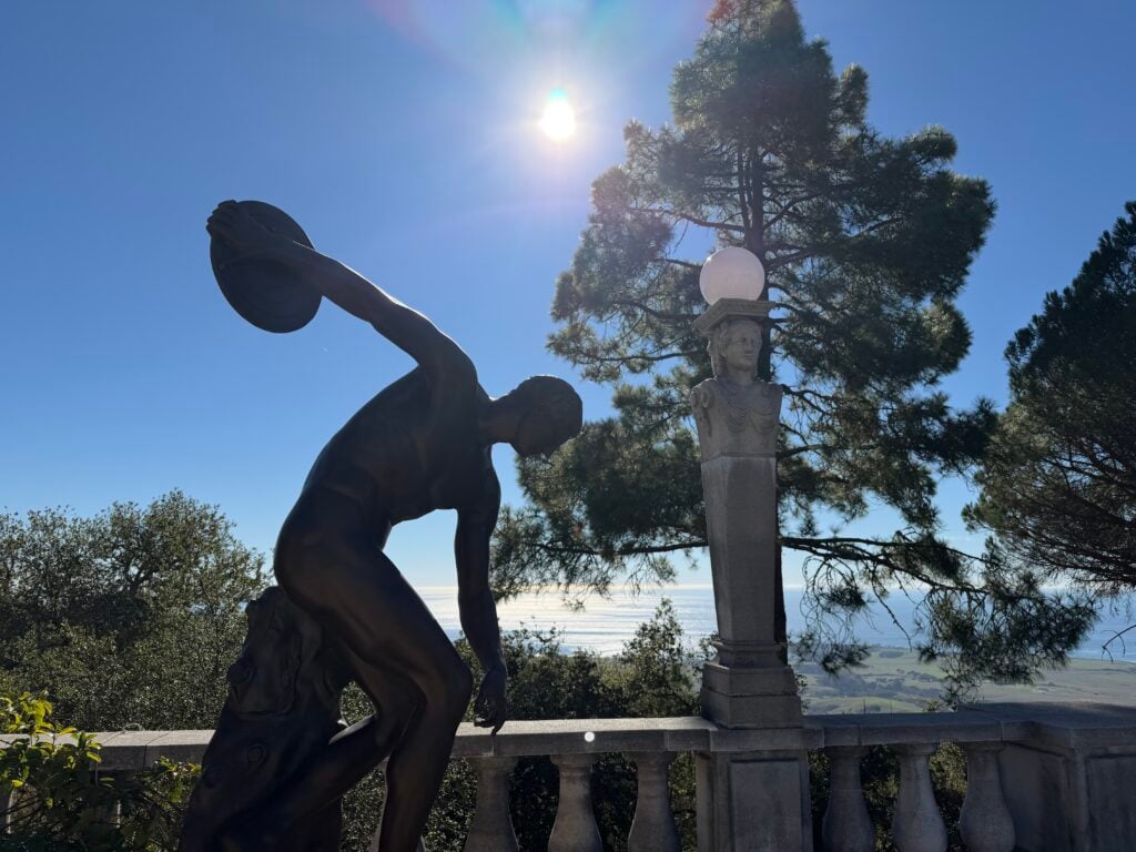 silhouette of statue on terrace with view of ocean