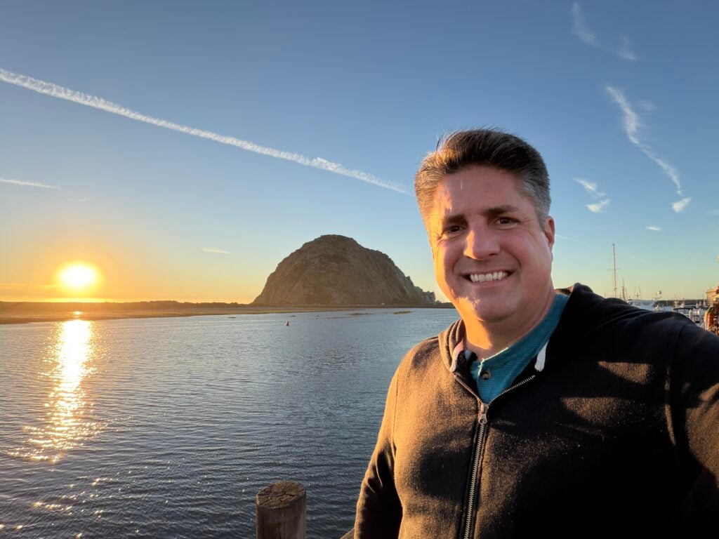 man standing in front of Morro Rock