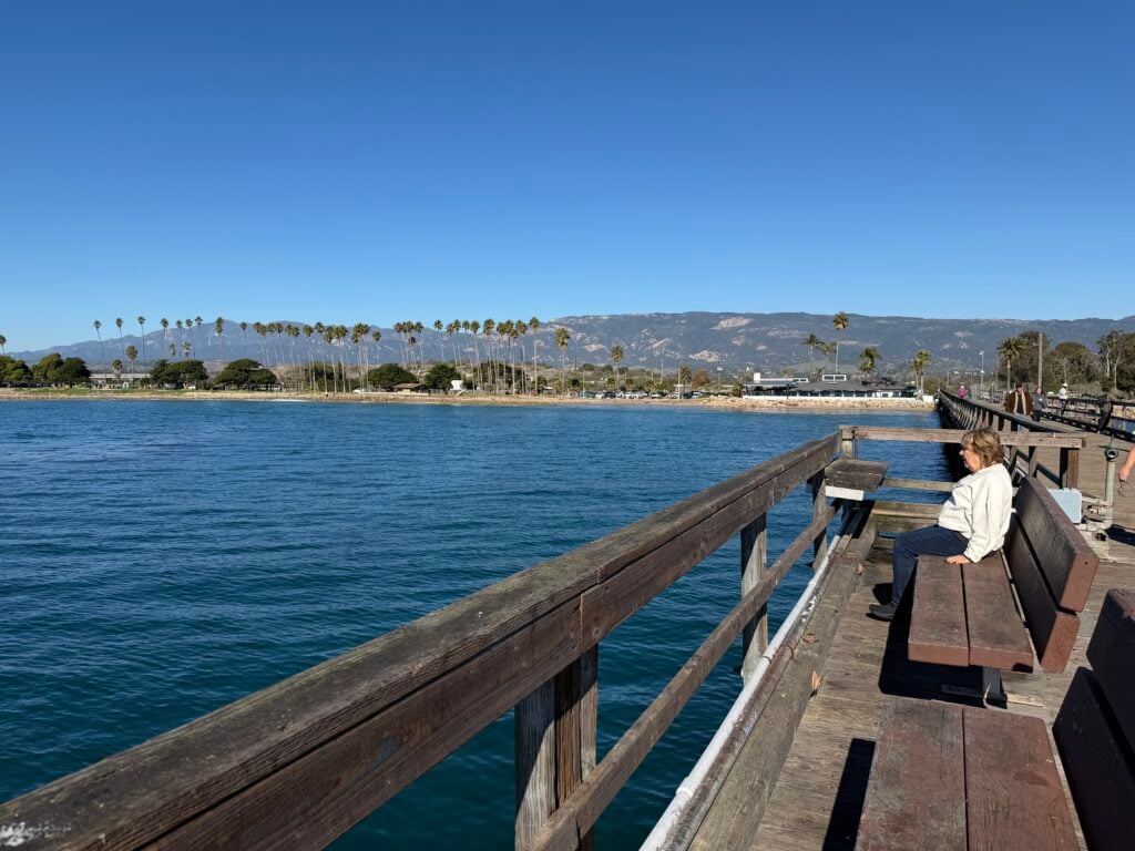 woman sitting on bench on pier