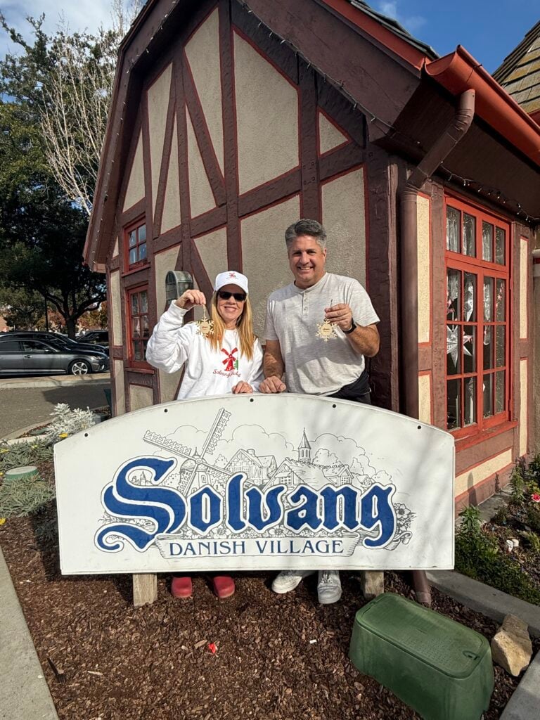 man and woman in front of Solvang Visitor Center holding ornaments