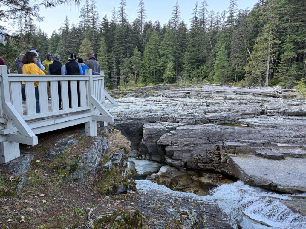 people standing on deck over river