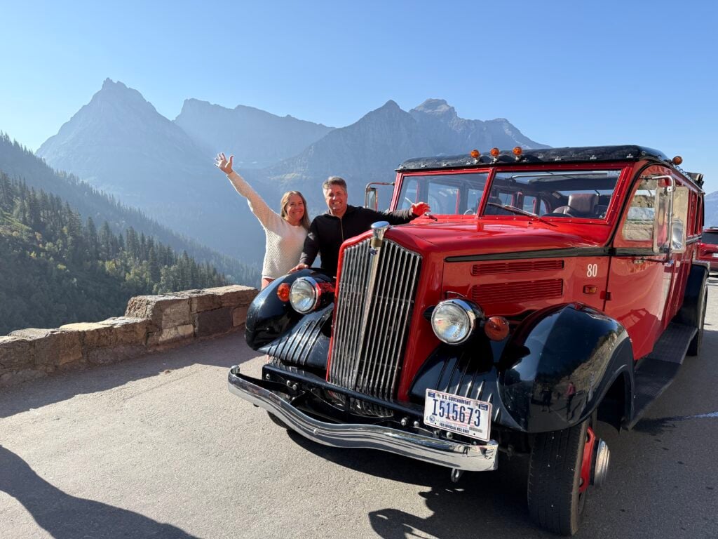 man and women next to Red Bus in Glacier