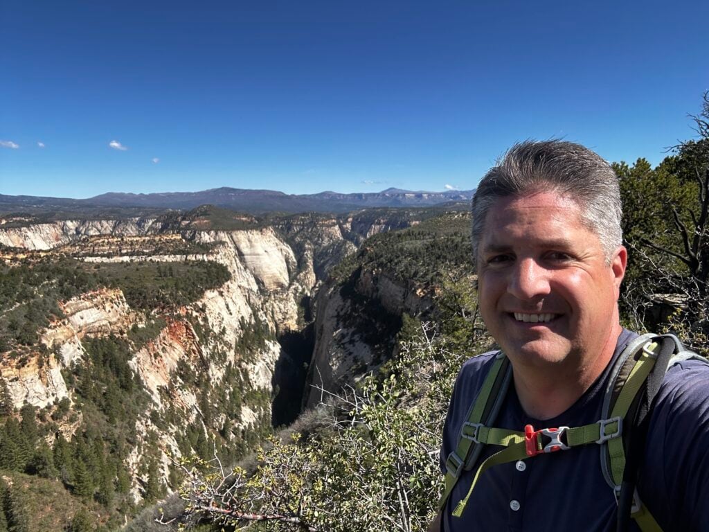 selfie of man standing on top of canyon