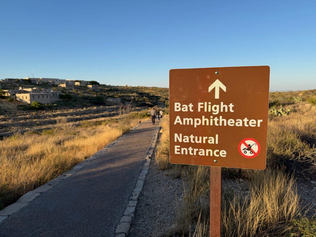 sign marking paved pathway to bat amphitheater