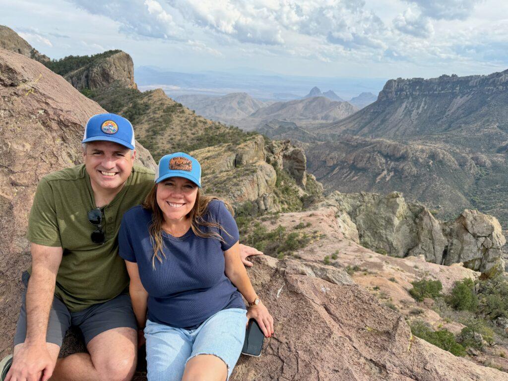 man and woman with view of valley behind