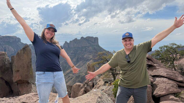 man and woman in front of view of mountains