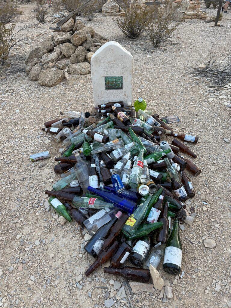 grave covered in glass bottles