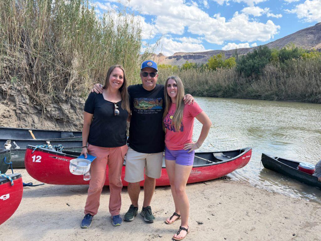 people in front of canoes near river
