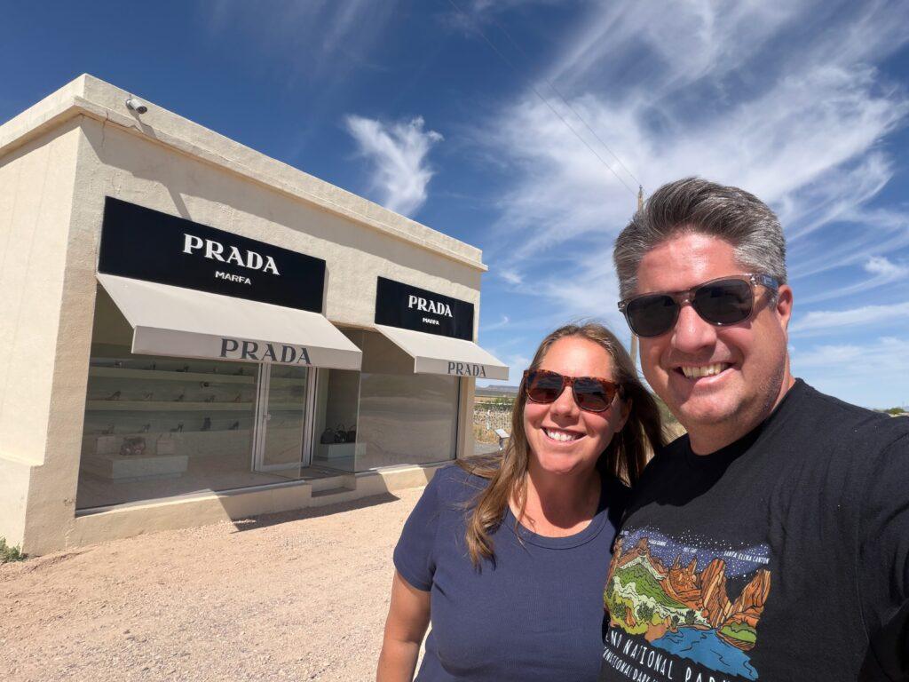 man and woman in front of Prada building at roadside stop