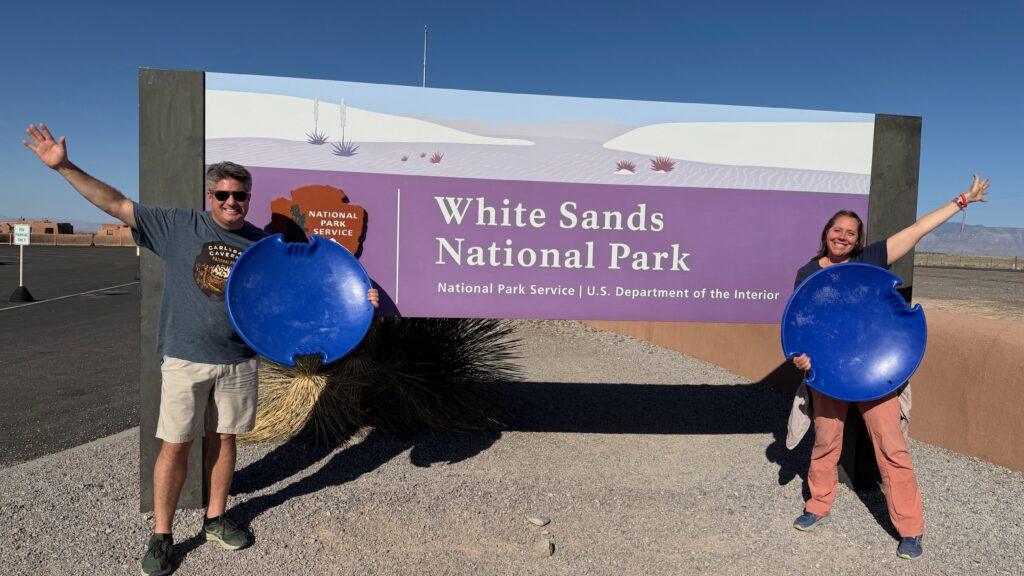 man and woman in front of White Sands National Park sign