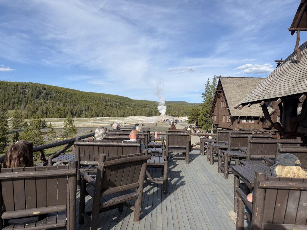 Viewing deck on top of building with Old Faithful geyser in background