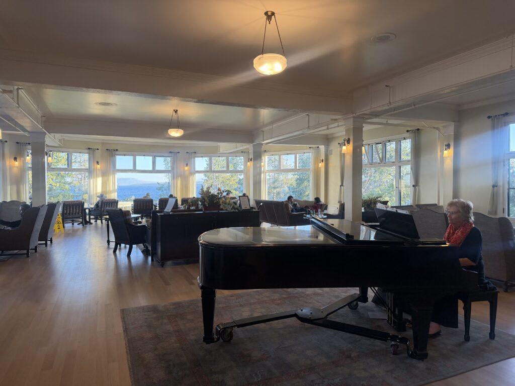 woman playing grand piano in lobby of hotel