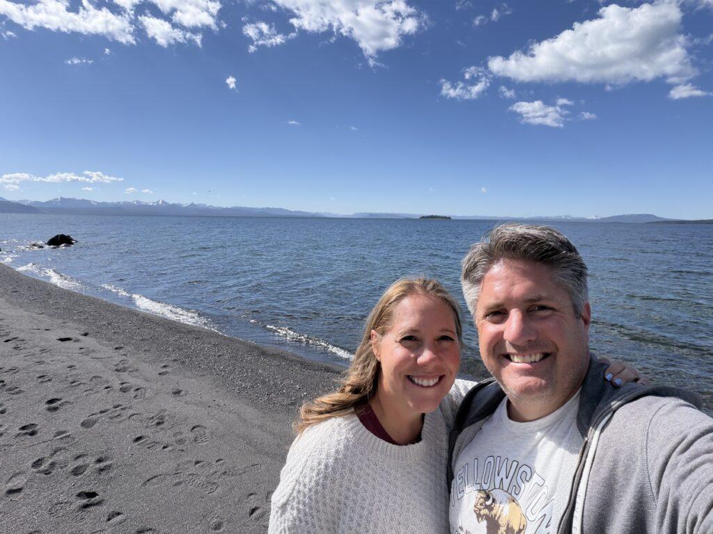 couple standing on beach near lake