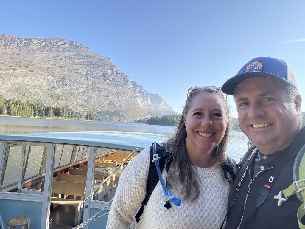 man and woman on boat on glacial lake
