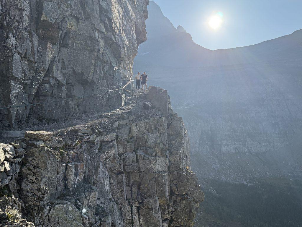 man and woman on hiking trail on edge of cliff