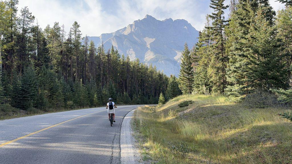 woman biking on road in mountains