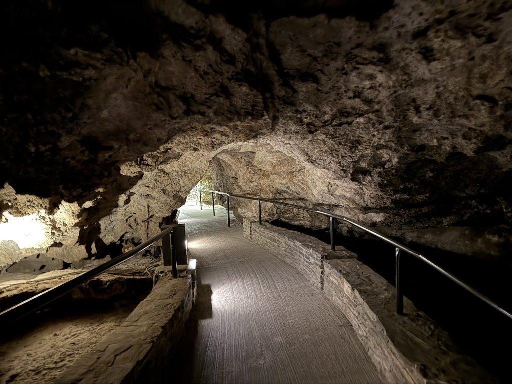 paved path through cave with hot springs