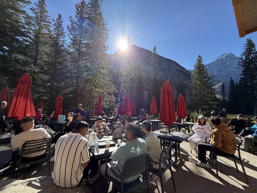 people sitting at tables on patio in mountains