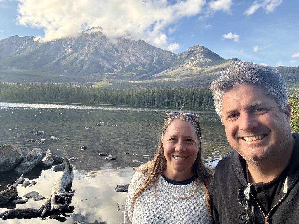 man and woman in front of mountain lake