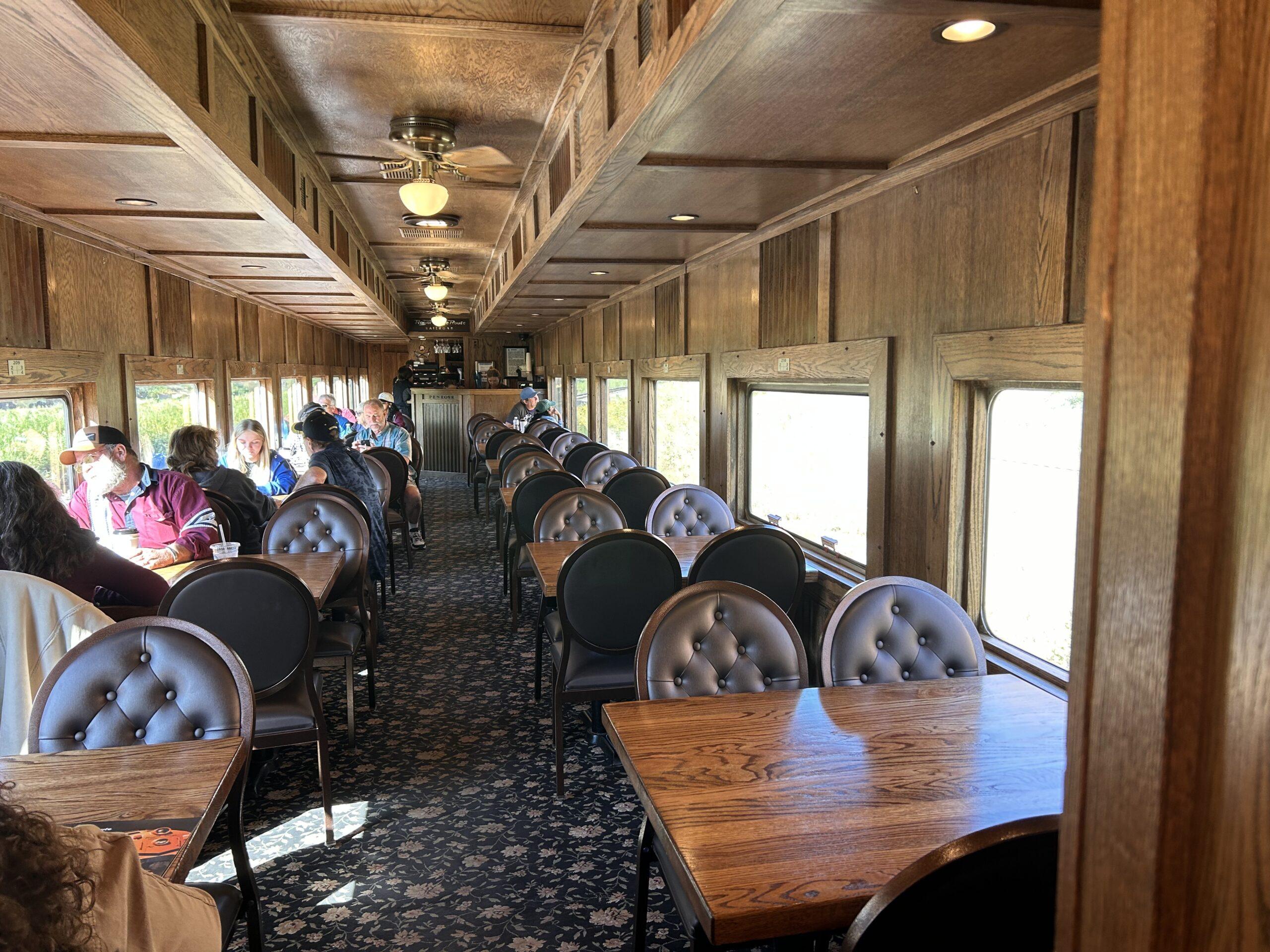 Wood-paneled Royal Gorge train car with padded chairs and tables beside large windows