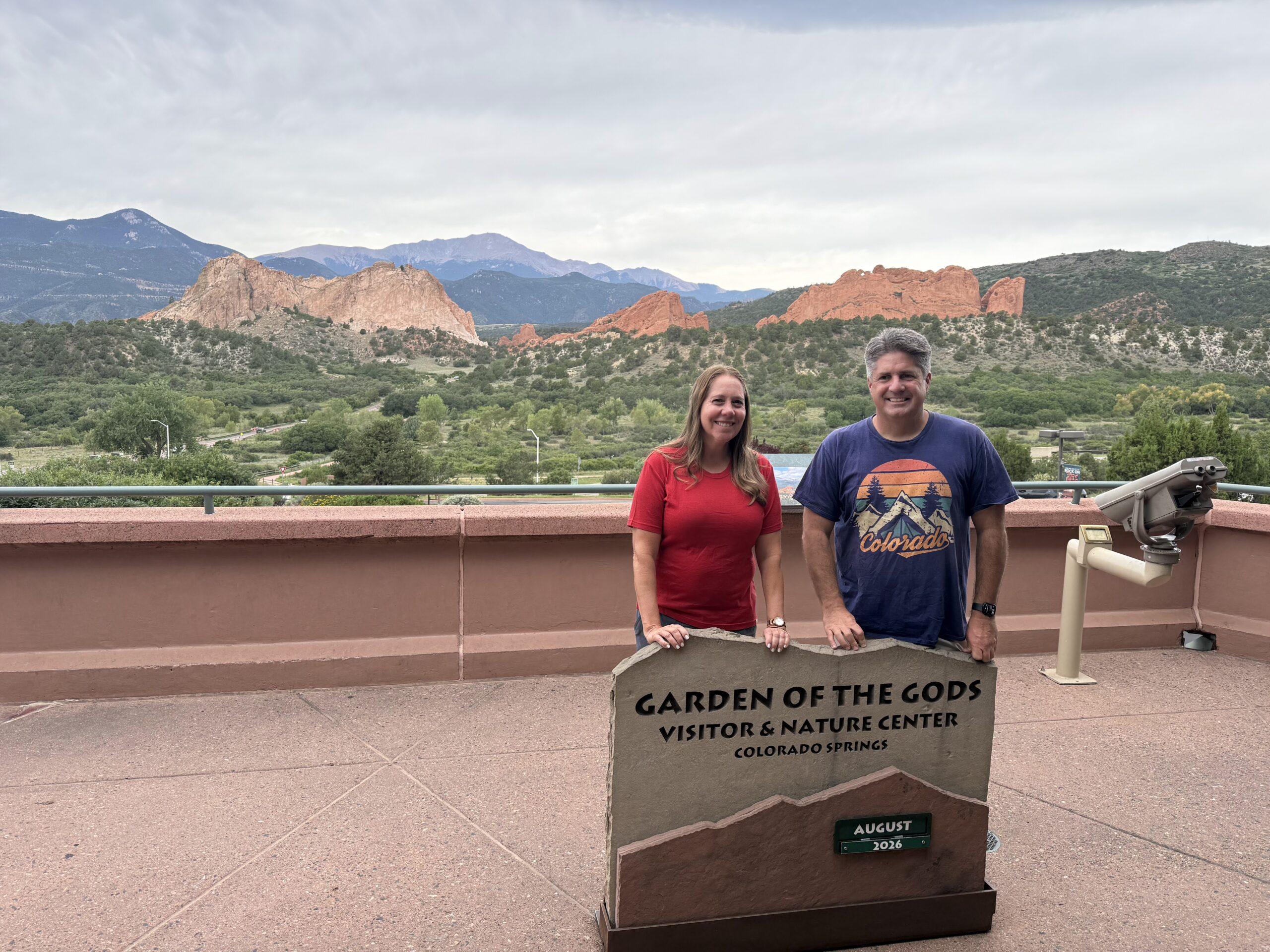 Cheryl and Matt on the visitor-center terrace with Garden of the Gods formations behind them