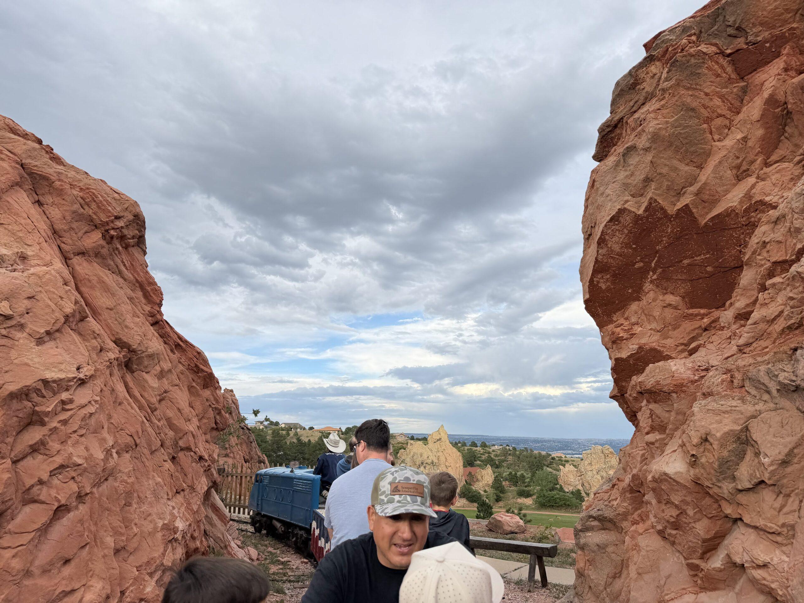 Passengers riding the small Flying W Ranch train between red rock formations