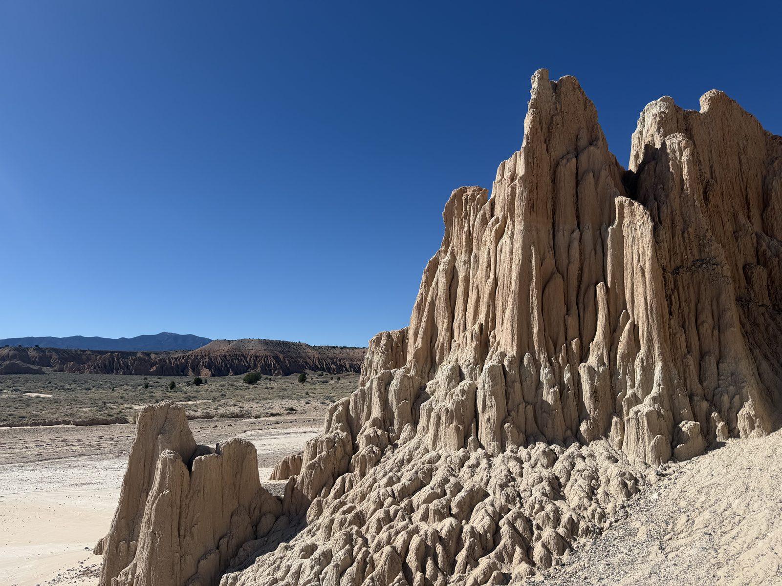 Tall, deeply eroded clay spires rise beneath a blue sky at Cathedral Gorge State Park.