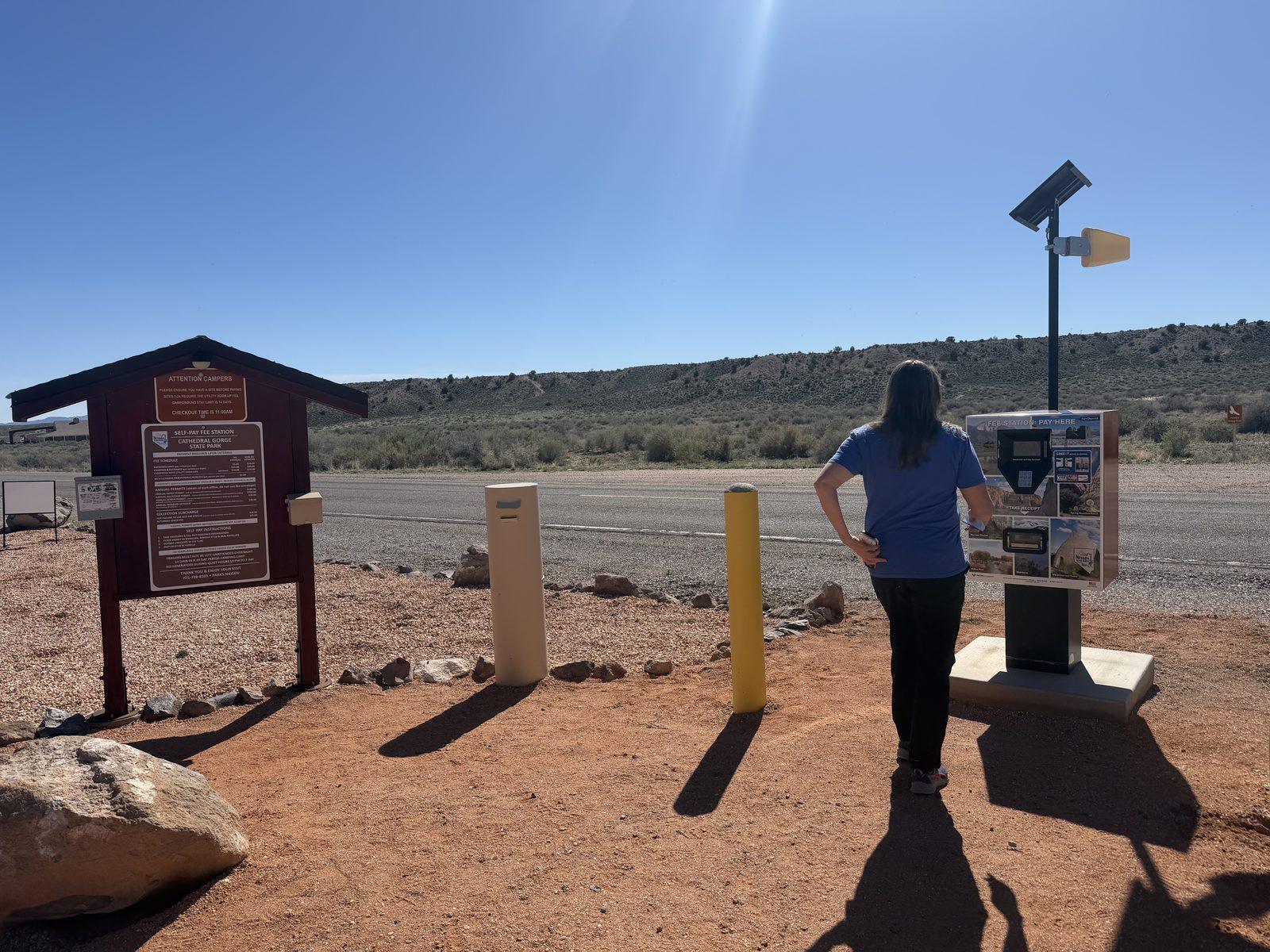 Cheryl uses the entrance-fee kiosk at Cathedral Gorge State Park.
