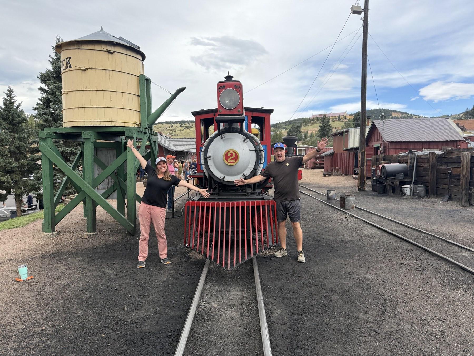 Matt and Cheryl standing with the No. 2 steam locomotive at the Cripple Creek railroad depot.