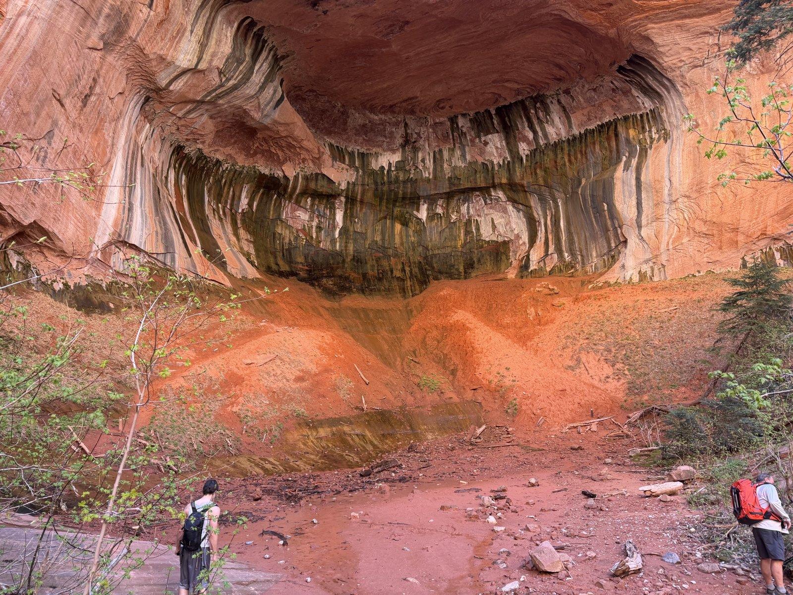 Hikers beneath the enormous Double Arch Alcove