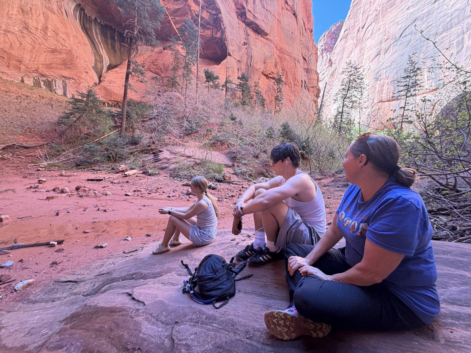 Family resting on a boulder at Double Arch Alcove