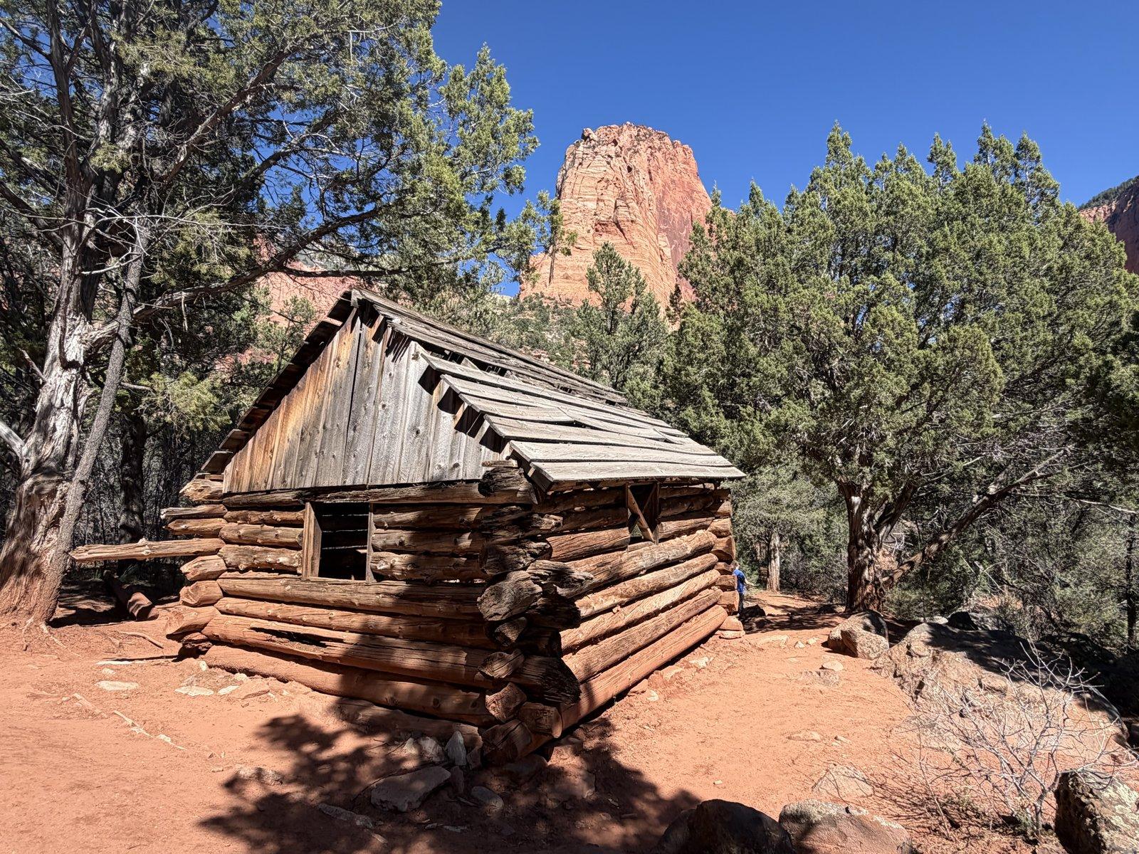 Historic log cabin below red cliffs on Taylor Creek Trail